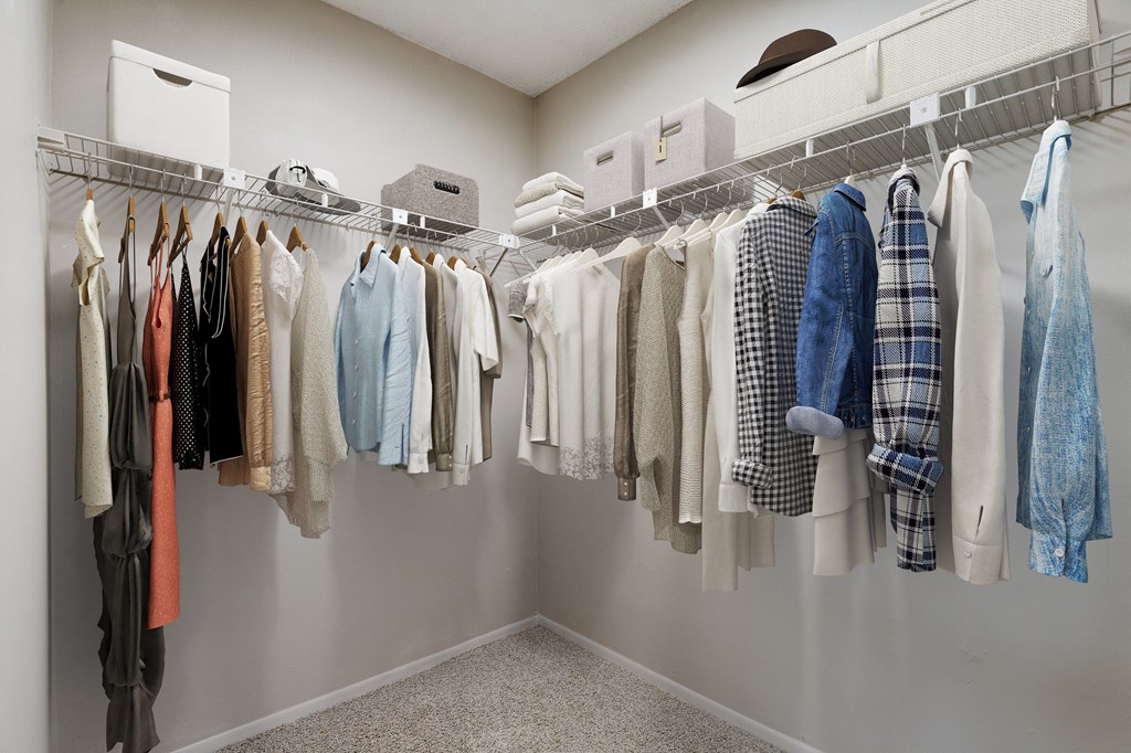 an image of a closet full of clothes hanging on a rack
