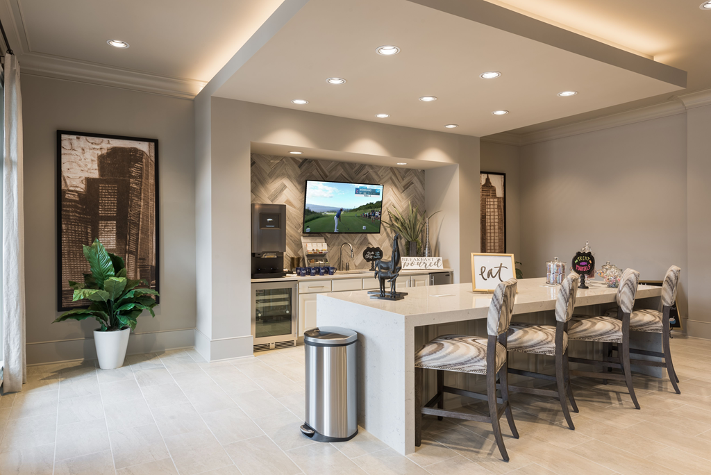a kitchen with a bar and chairs and a television