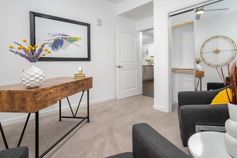 A living room with a wooden table and a framed picture on the wall.