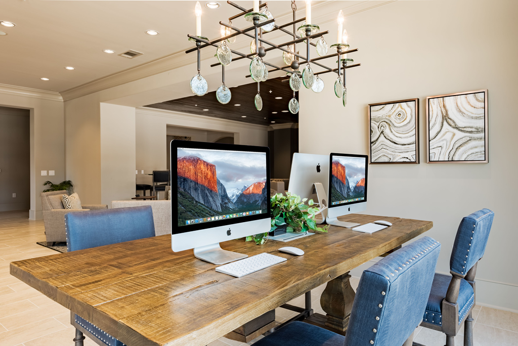 a home office with three computer monitors on a wooden desk