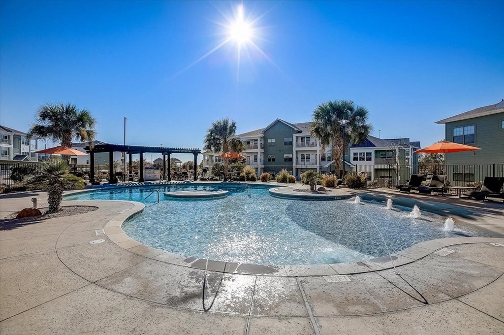 a swimming pool with palm trees and buildings in the background
