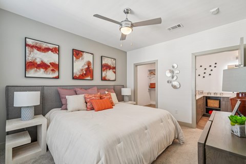 A bedroom with a large bed and a ceiling fan.