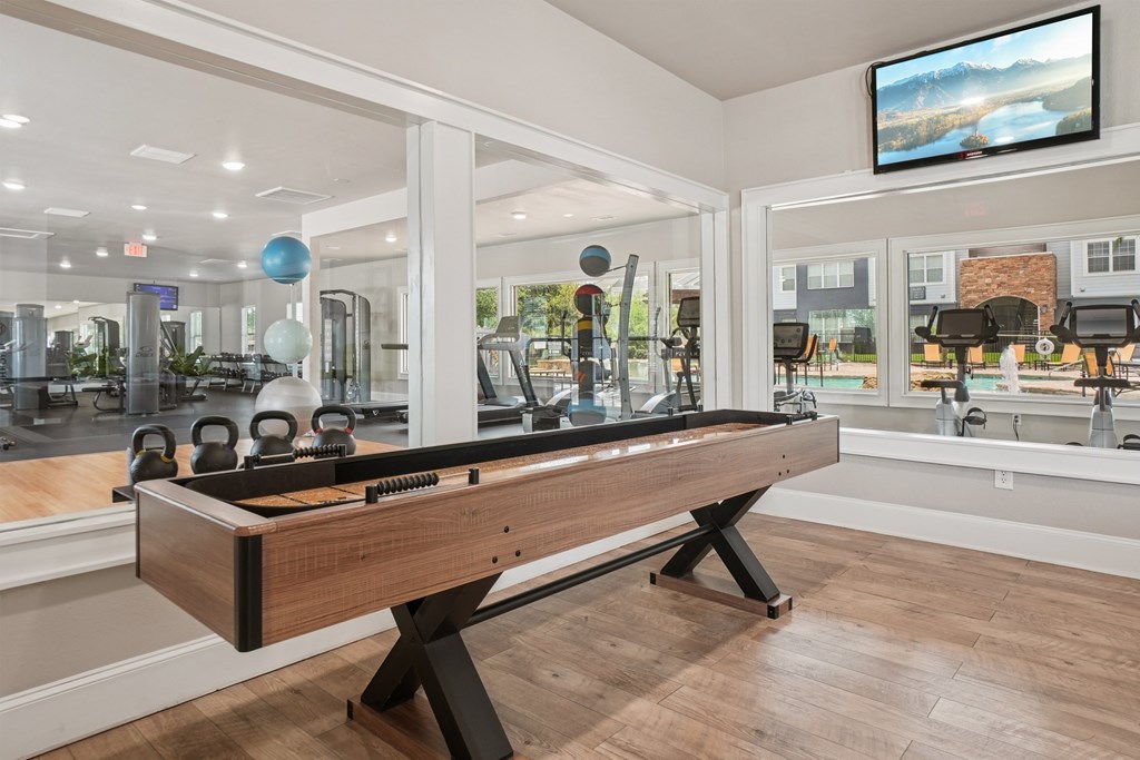 A room with a pool table and a television mounted on the wall.