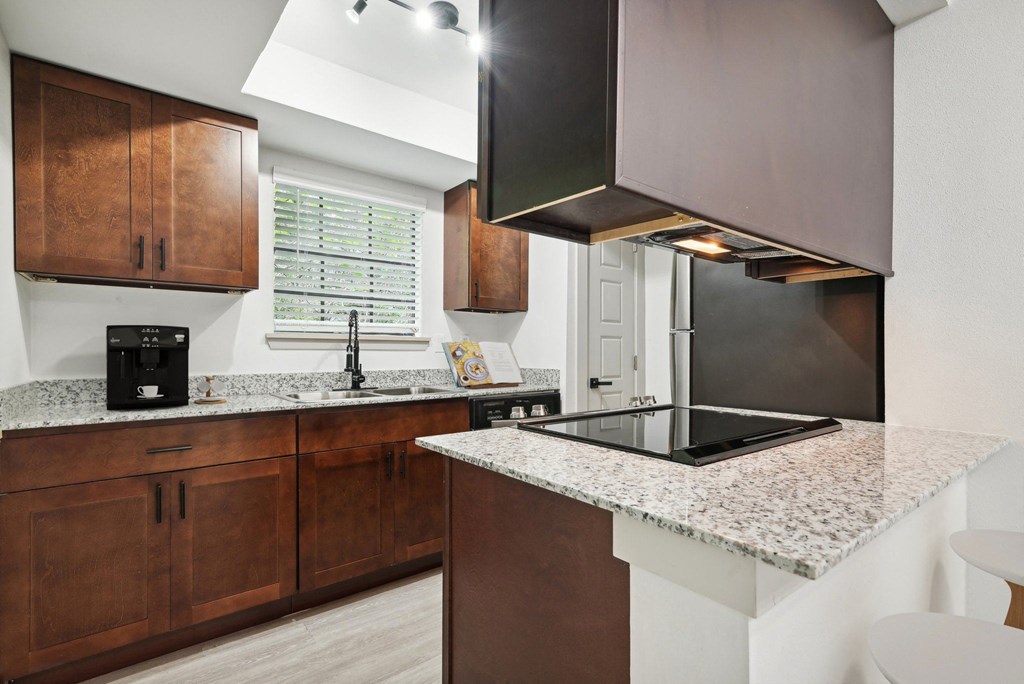 a kitchen with granite counter tops and wooden cabinets