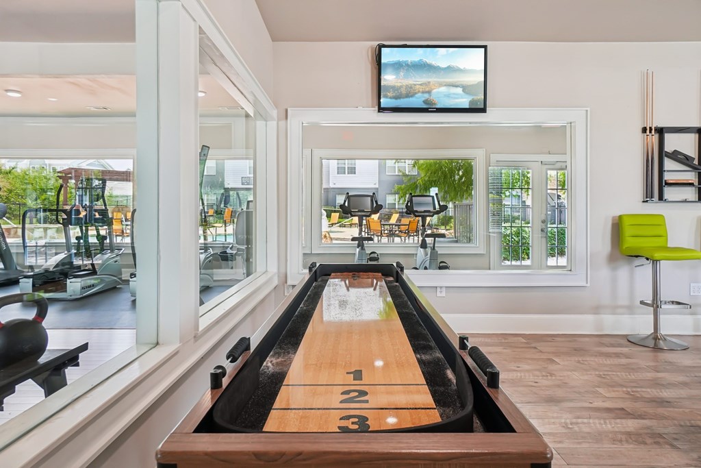 A room with a bowling alley and a television mounted on the wall.