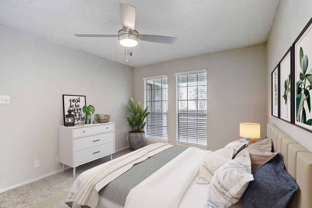 an empty bedroom with a bed and a ceiling fan