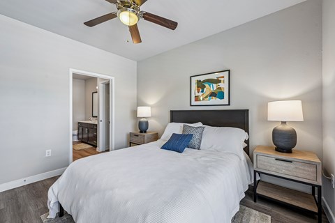 A bedroom with a large bed and a ceiling fan.