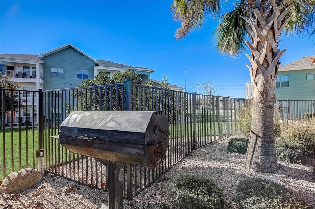 a mailbox in front of a fence with a palm tree
