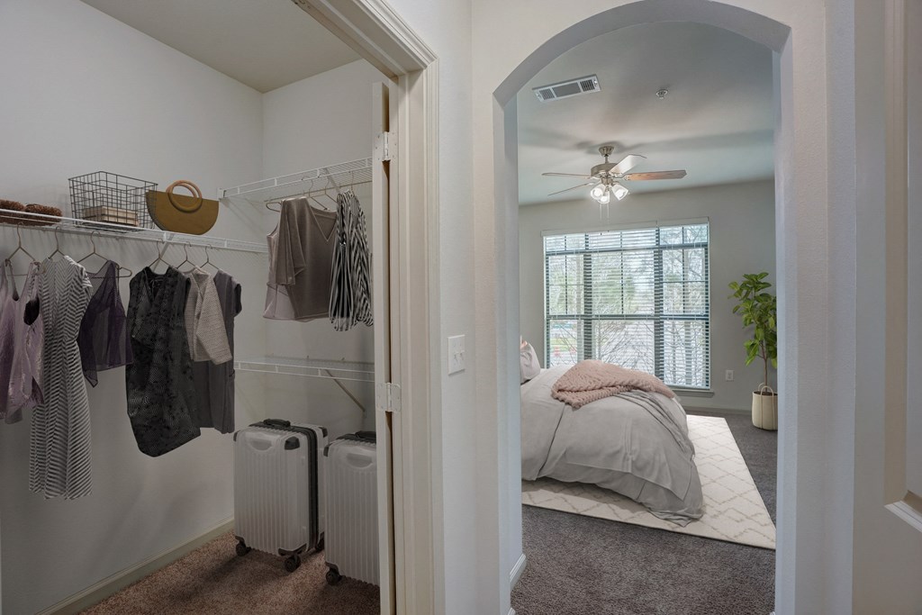 a bedroom with a closet and a bed and a ceiling fan