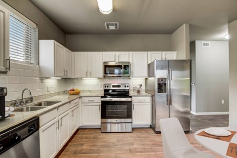a kitchen with stainless steel appliances and white cabinets