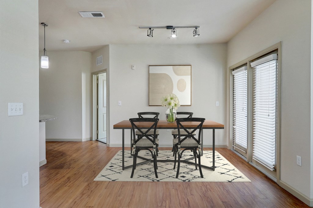 an empty living room with a dining room table and chairs