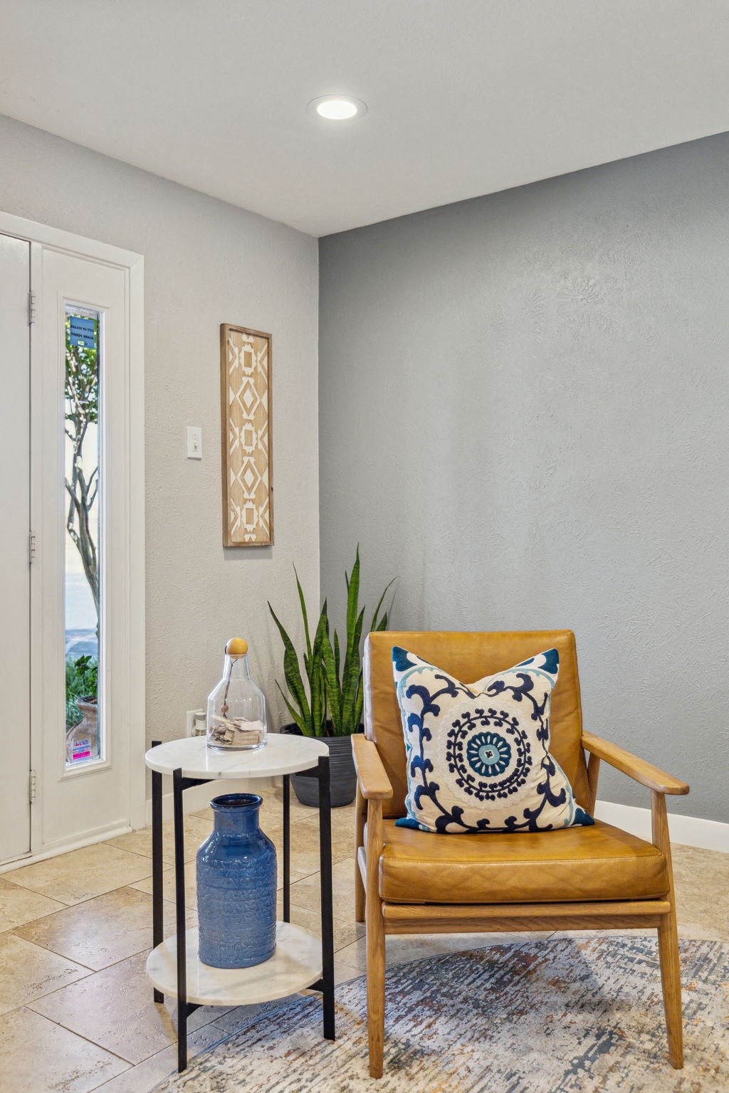 a chair with a pillow in a room with a table and a door