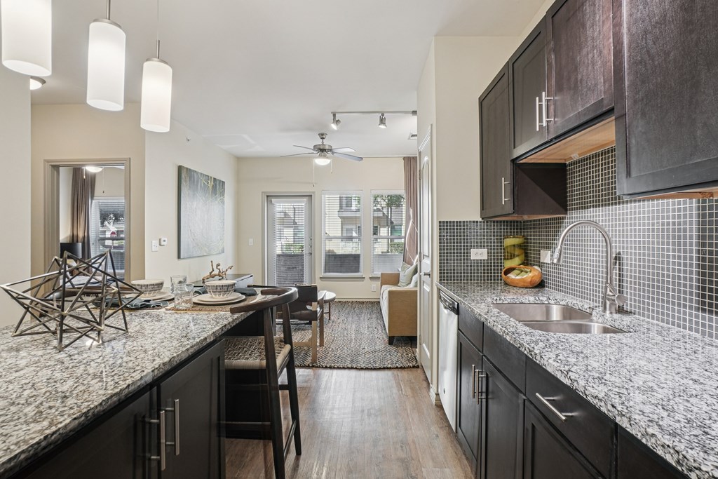 A modern kitchen with dark wood cabinets and a granite countertop.
