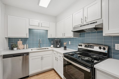 A kitchen with white cabinets and a black stove top oven.