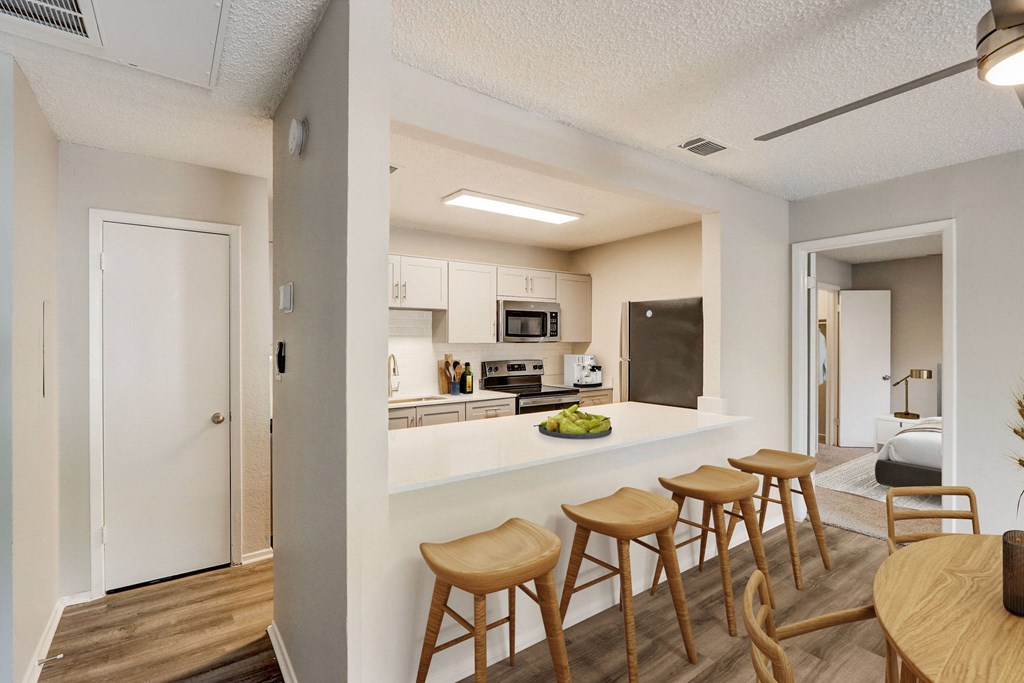 a kitchen with a white counter top and wooden stools