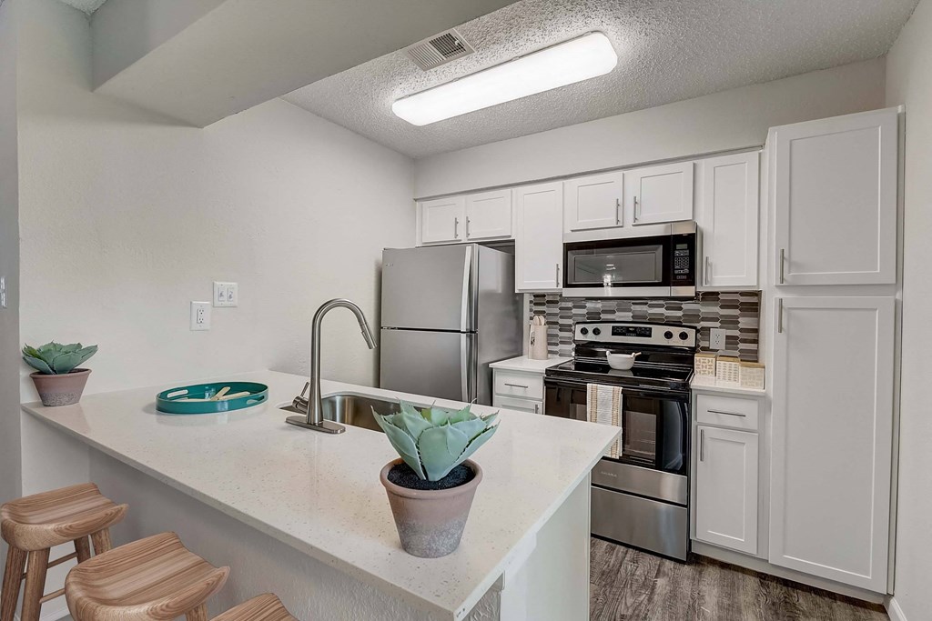 a kitchen with white cabinets and stainless steel appliances