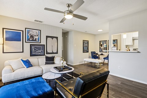 A living room with a white couch and a blue ottoman.