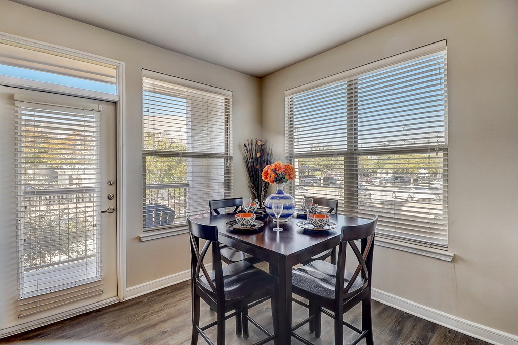 a dining room with two windows and a table with chairs