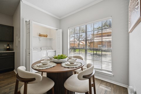 A dining room with a round table and chairs.