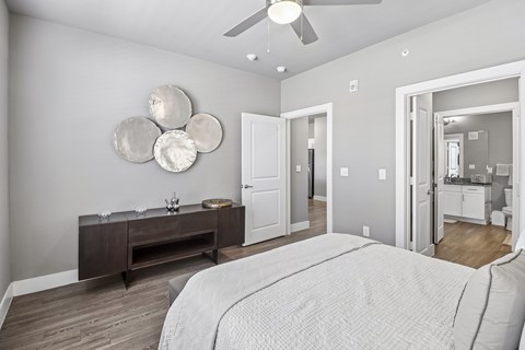 A bedroom with a large bed and a wooden dresser.