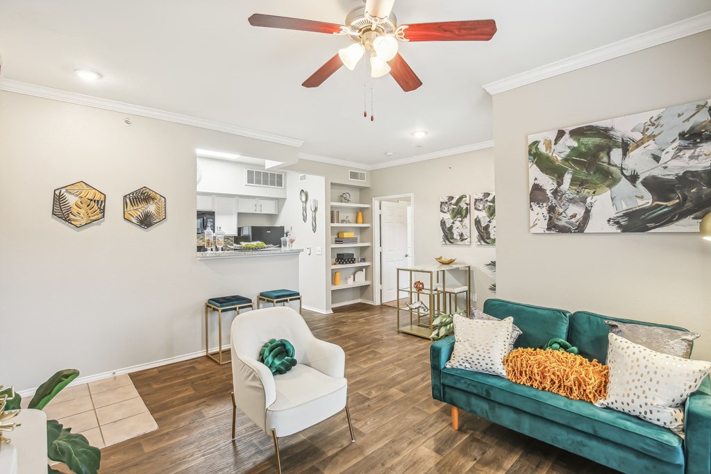 A living room with a green couch and a white chair.