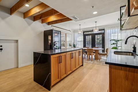 A modern kitchen with wooden cabinets and black countertops.
