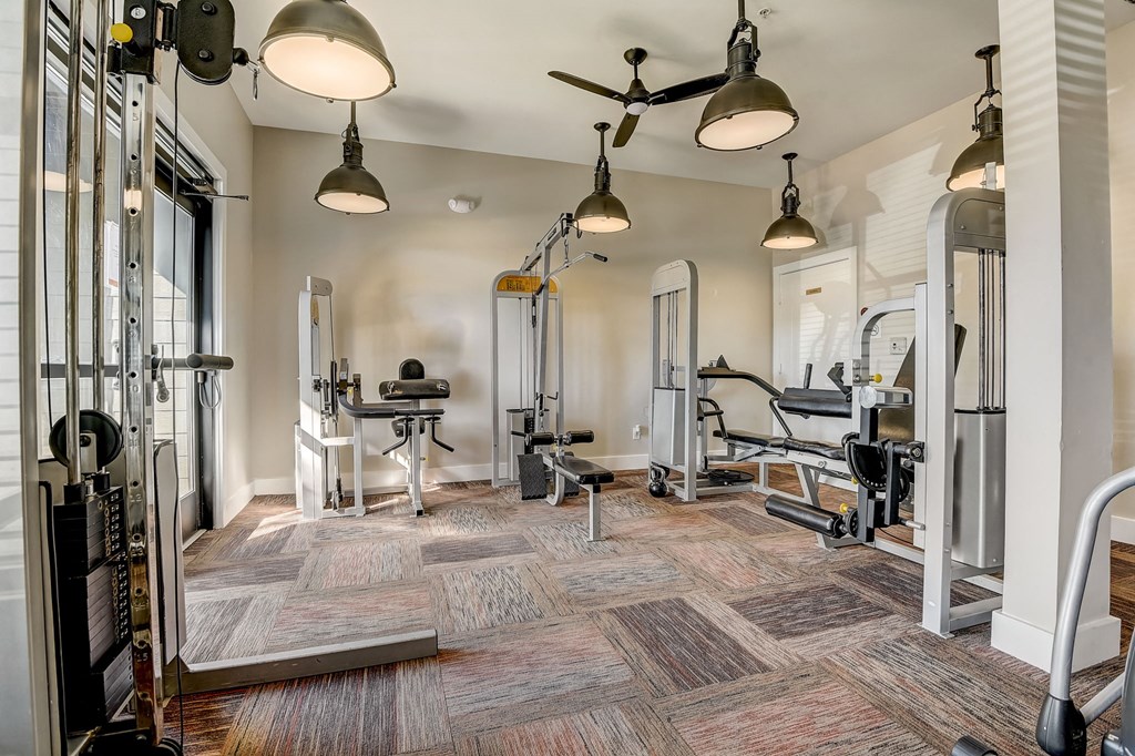 a gym with weights machines and a ceiling fan