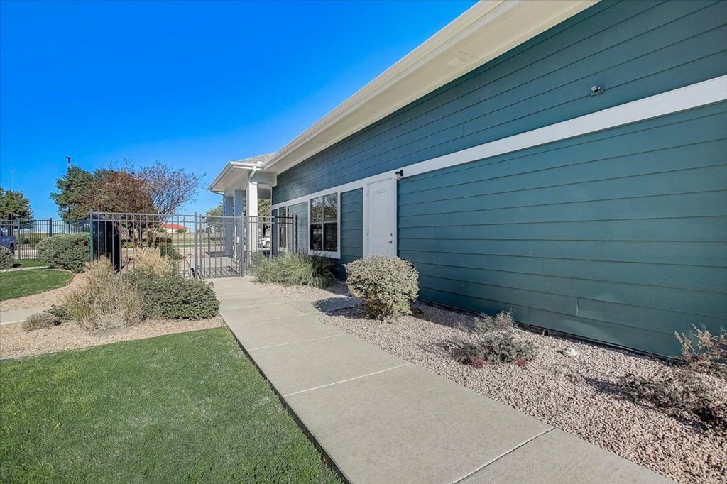a blue house with a sidewalk in front of it