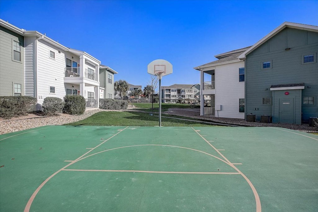 a basketball court with apartments in the background