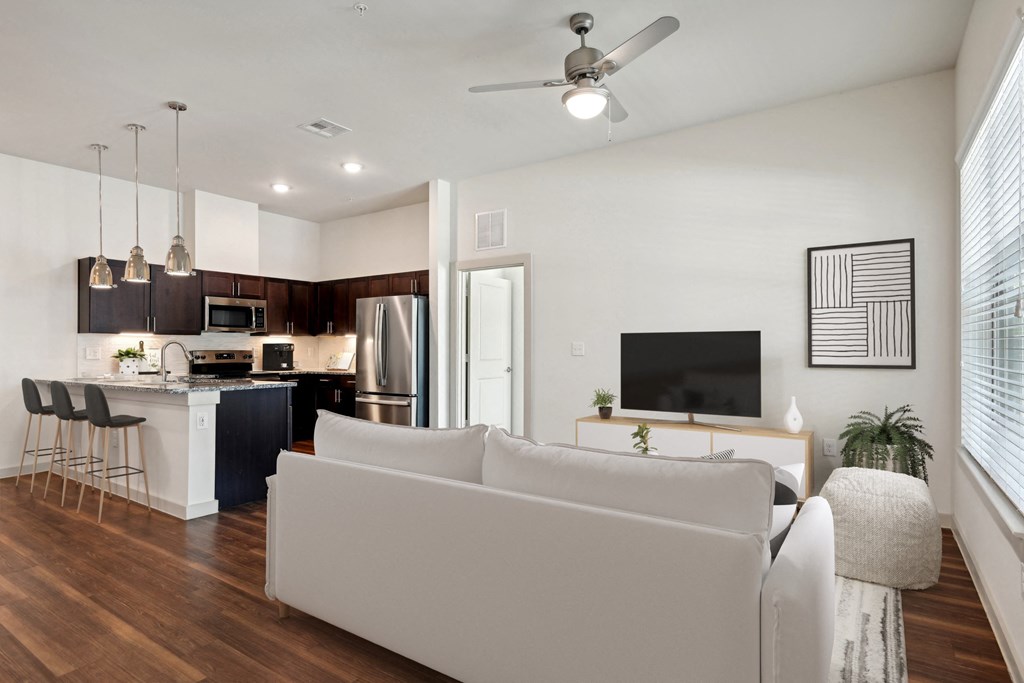 a living room and kitchen with a couch and a tv