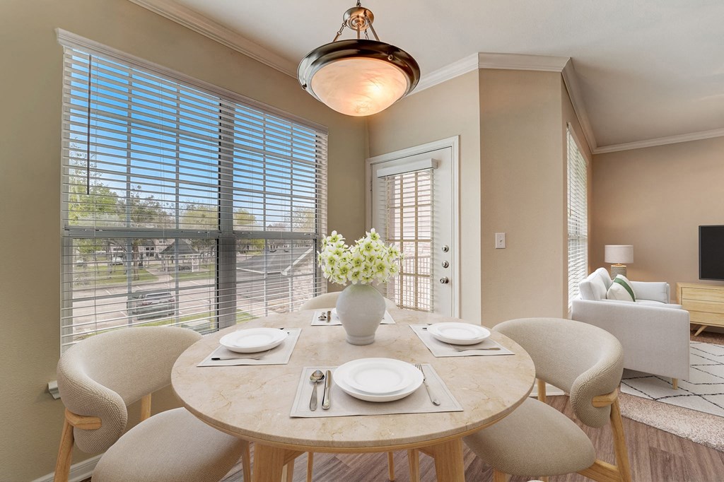 a dining room with a table and chairs and a large window