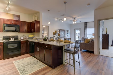A kitchen with dark wood cabinets and a black oven.