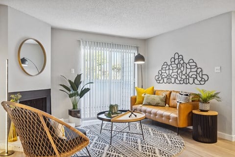 a living room with a yellow couch and a black and white rug