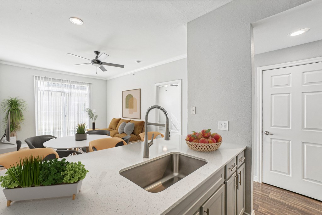A modern kitchen with a dining area and a ceiling fan.
