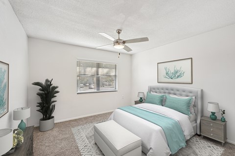 A bedroom with a large bed and a ceiling fan.