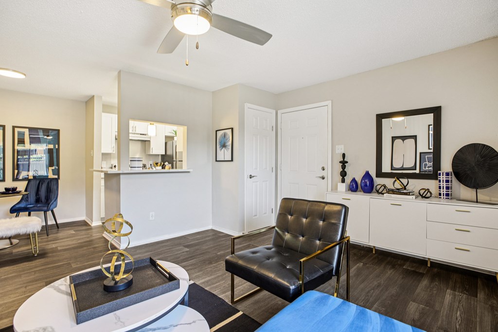 A living room with a black leather chair and a white coffee table.