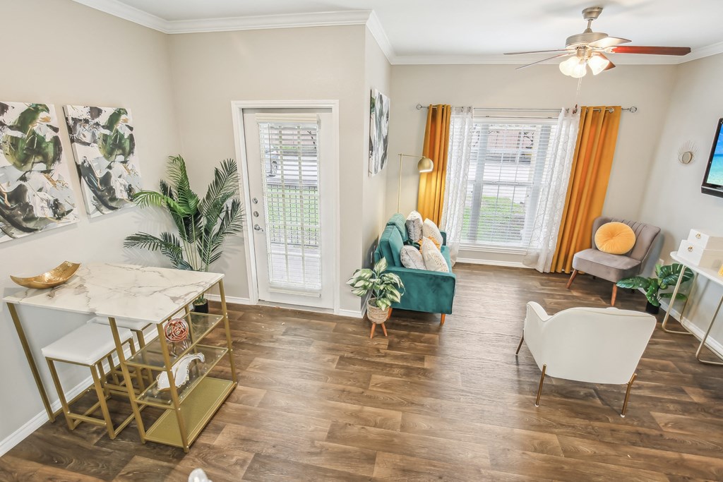 A living room with a green couch and a white chair.