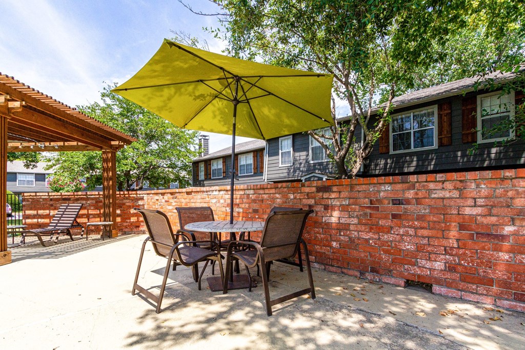 a patio with a table and chairs and an umbrella