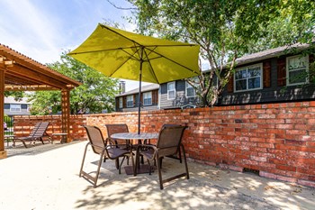 a patio with a table and chairs and an umbrella - Photo Gallery 20