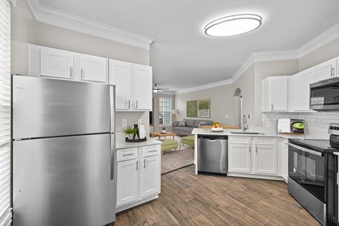a renovated kitchen with stainless steel appliances and white cabinets