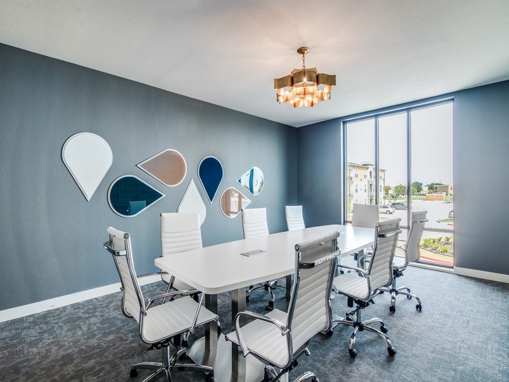 a conference room with a white table and chairs and a large window