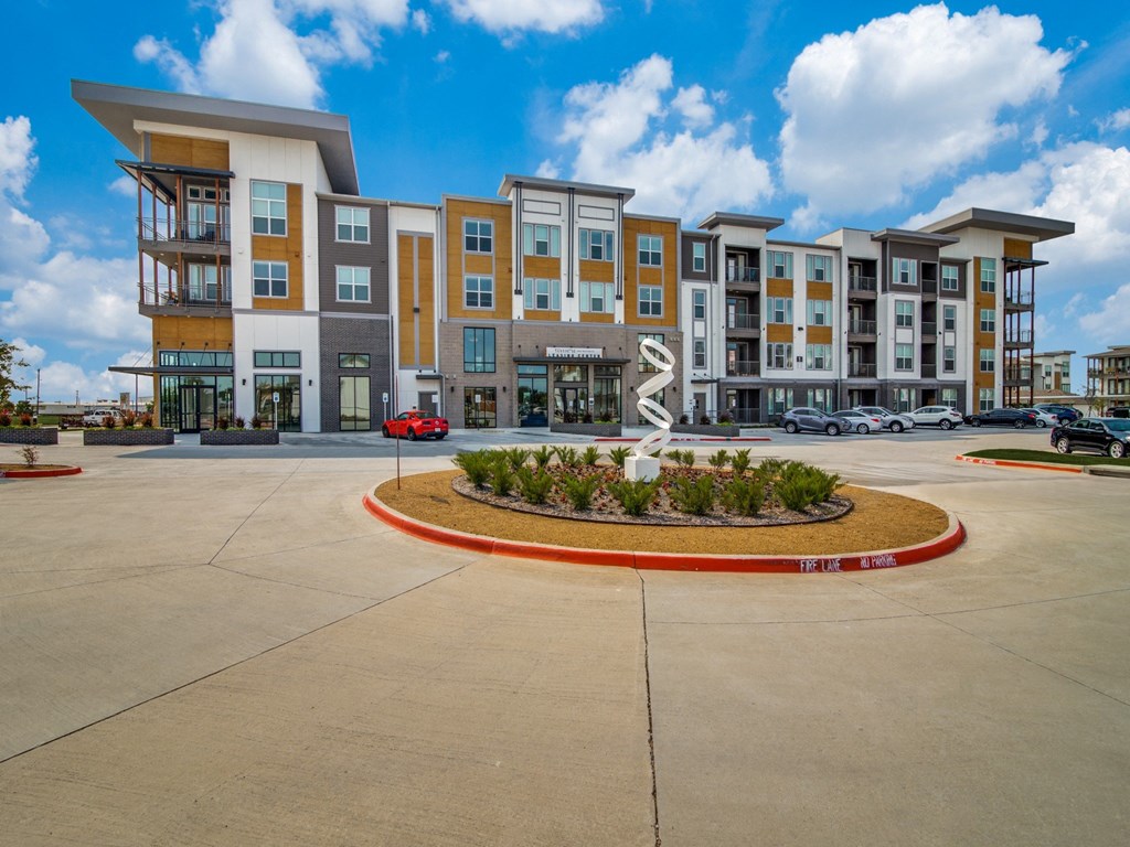 an empty parking lot with an apartment building in the background
