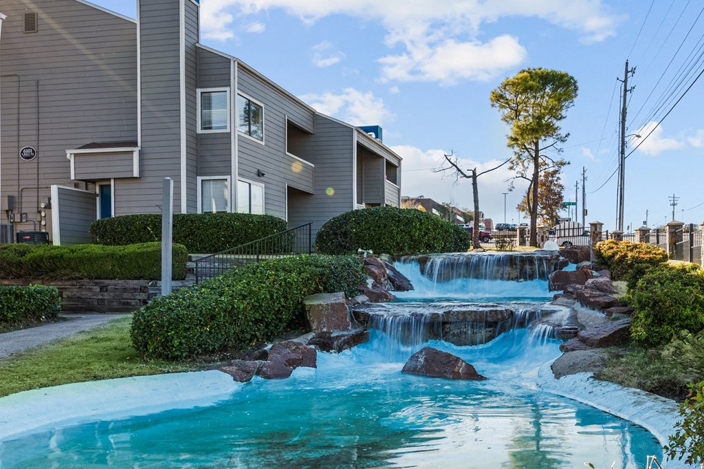 a man made waterfall in front of a house