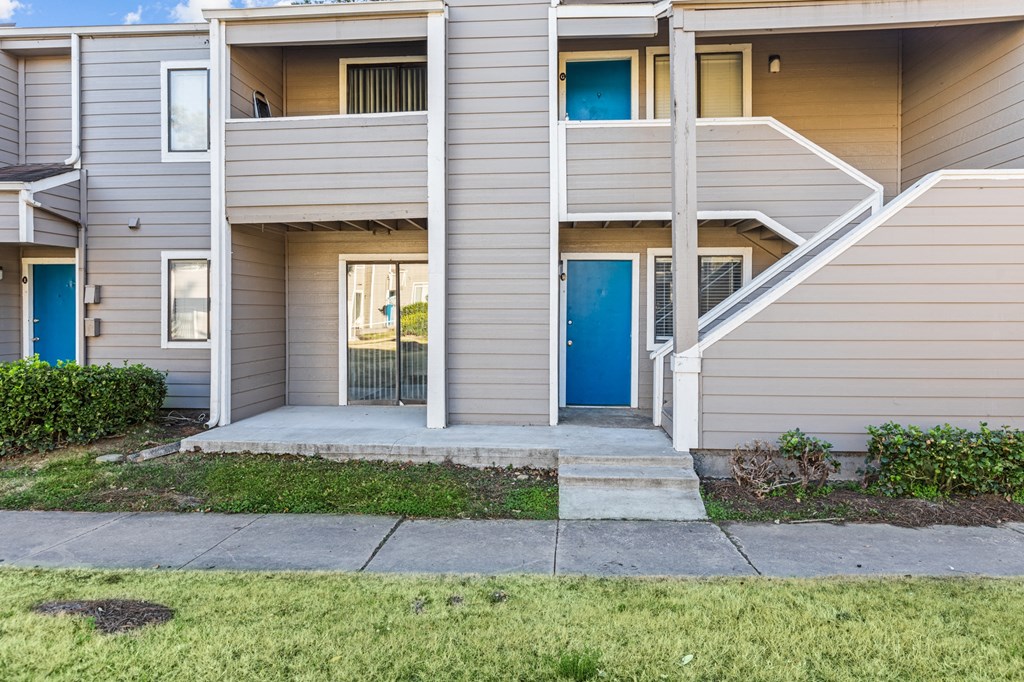 the entrance to an apartment building with stairs and a blue door