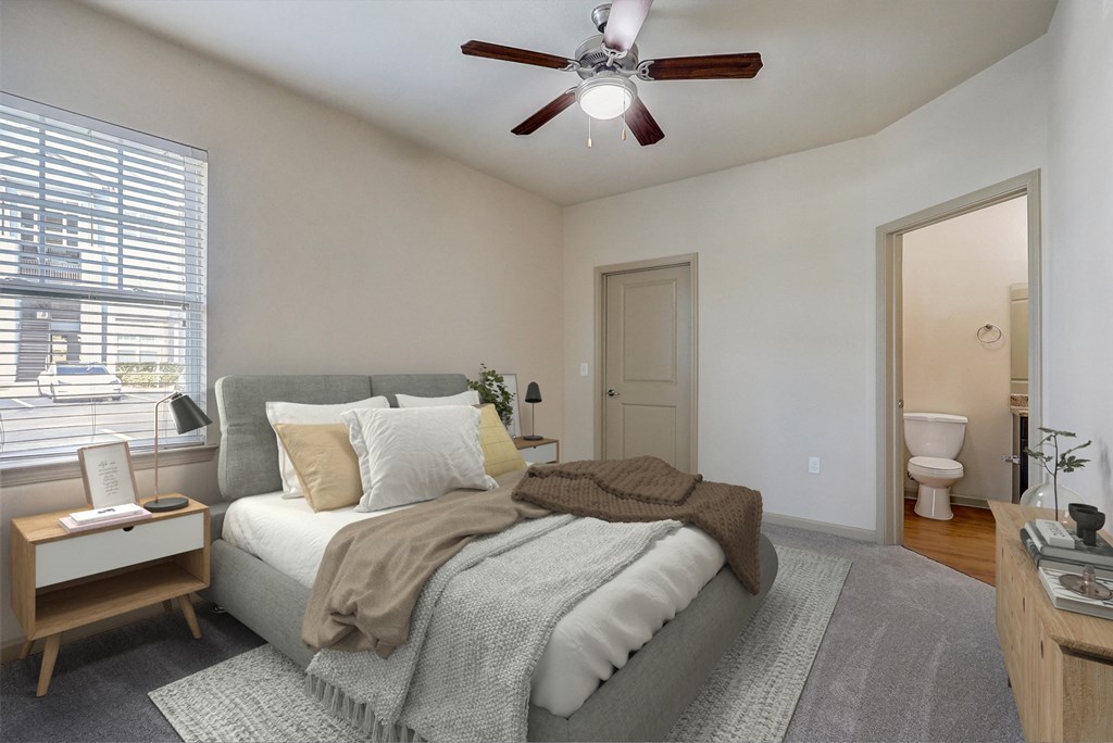 an empty bedroom with a bed and a ceiling fan