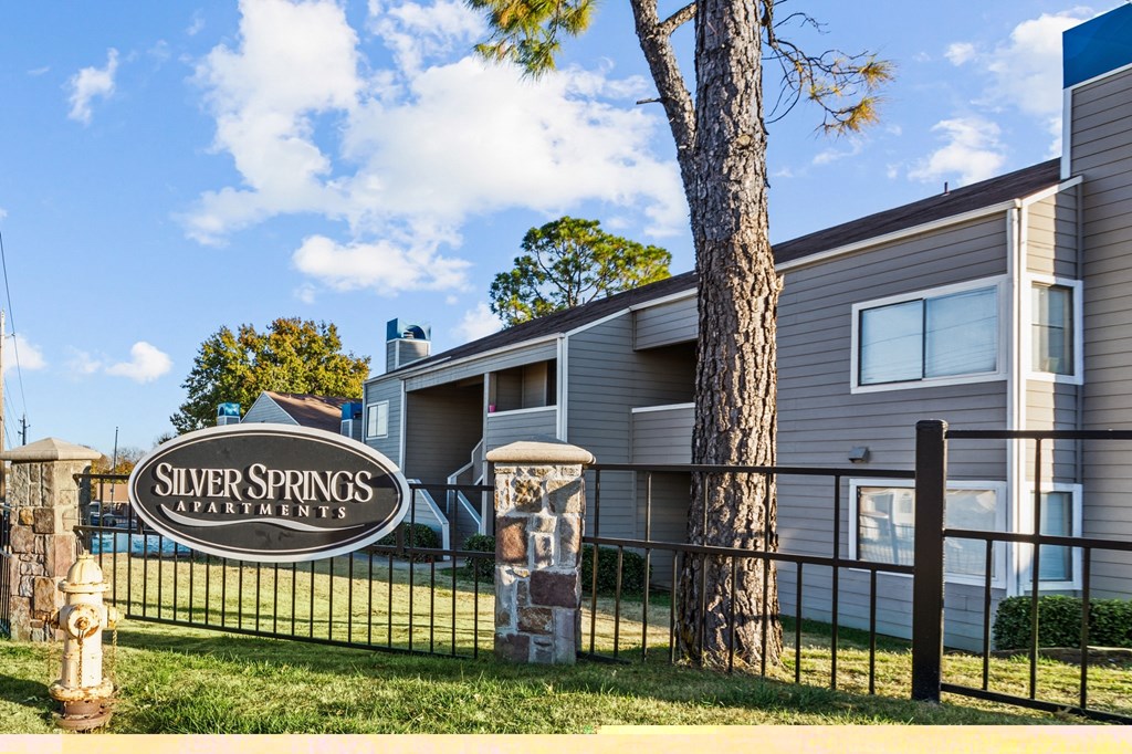 a silver springs apartment building with a sign on a fence