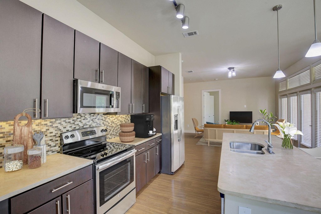 a large kitchen with stainless steel appliances and marble counter tops