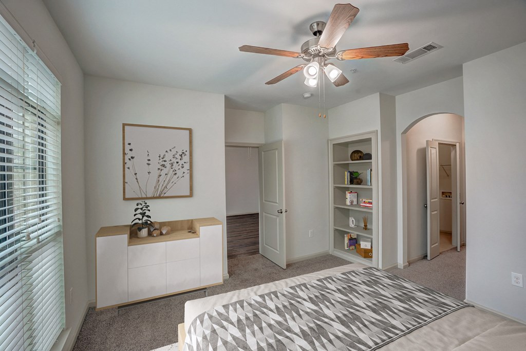 a bedroom with a bed and a ceiling fan