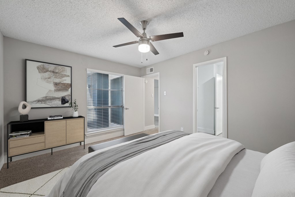 a bedroom with a large bed and a ceiling fan