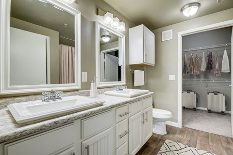 a bathroom with two sinks and a toilet and a mirror